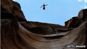 diver jumping off a cliff edge