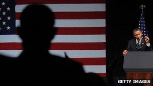 President Obama giving a speech with US flag behind him