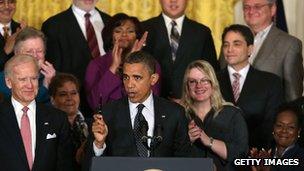 President Barack Obama holds up a pen while speaking to the media in the East Room of the White House on 9 November.