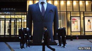 A man walks past a big suit at a shopping mall in Shenyang, Liaoning province 28 October 2012