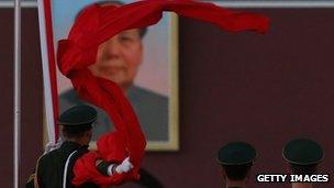 A paramilitary police in front of a giant portrait of the late chairman Mao Zedong in Beijing, 13 November 2012