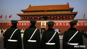 Paramilitary policemen standing guard in front of the giant portrait of former Chinese Chairman Mao Zedong at Beijing's Tiananmen Square, 15 November 2012