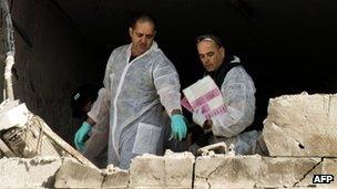 Israeli forensic experts inspect a damaged house hit by a rocket fired by Palestinian militants from the Gaza Strip in the southern Israeli city of Kiryat Malachi (15 Nov 2012)