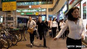 Israelis in Tel Aviv run for cover during a rocket attack on Sunday