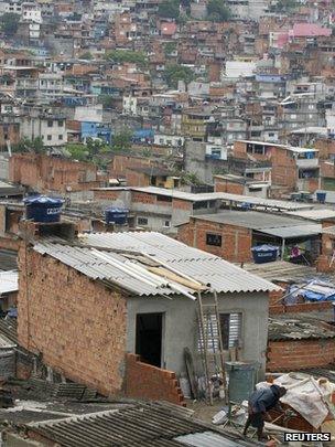 A man works on a house under construction in the Brasilandia slum in Sao Paulo