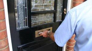 Postman putting letter through a letter-box