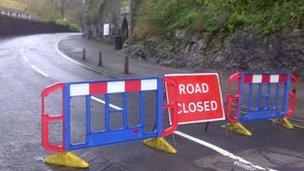 Road closed sign and barrier across the main road in Cheddar