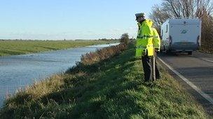 Fire officer and police at scene of river death