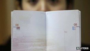 A woman holding up the new Chinese passport with a controversial map