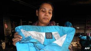 A union official hold a pair of trousers from Sean Combs ENYCE line at the burnt-out Tazreen factory