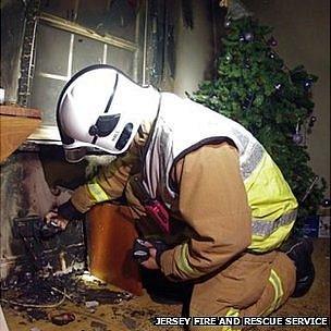 Firefighter inspects Damage caused by fire in St Helier flat