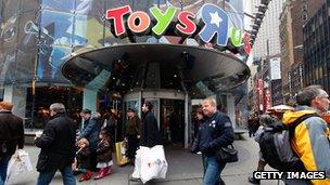 Shoppers walk outside of a toy store.