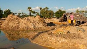 Fourteen year-old Htet Aung Win collects water from a polluted pond to help his family extract copper from tailings left by the mine.