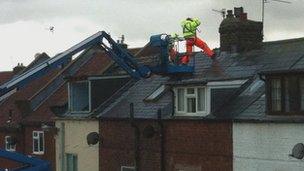 Contractors on the roof of the row of houses in Whitby