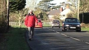 Walker on Isle of Wight road without footpath