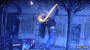 A protester throws a firework during demonstrations in Maribor, Slovenia, 3 December 2012