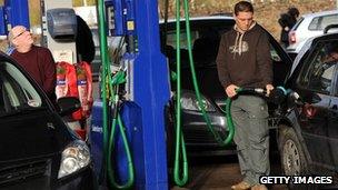 Men fill up cars with petrol