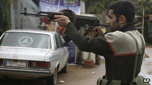 A Sunni gunman fires his weapon during clashes that erupted between pro and anti-Syrian regime gunmen in Tripoli, Lebanon, 5 Dec