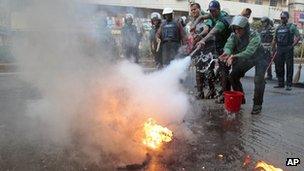 Policemen douse flames during a Jamaat-e-Islami demonstration in Dhaka on 4 December 2012