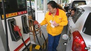 An attendant filling petrol at a fuel station in China