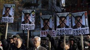 South Korean protesters shout slogans as they hold the pictures of North Korean leader Kim Jong-un with text saying "Out Kim Jong-un" in Seoul, South Korea, 12 December 2012