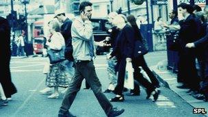 Man on mobile phone crossing road