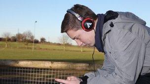 Plentyn yn gwisgo clustffonau