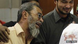 Amtiaz Khan (left), brother of Nasima Bibi, a female worker of an anti-polio drive campaign who was shot by gunmen, mourns her death at a hospital morgue in Karachi December 18, 2012.