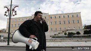 A Greek public sector worker outside the country's parliament, protesting about spending cuts