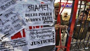 Indian police officers lock the gate of the police station during a protest condemning the gang rape of a 23-year-old student on a city bus late Sunday in New Delhi, India, Tuesday, Dec. 18, 2012. T