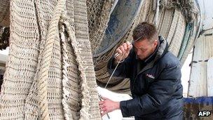 French fisherman mending nets