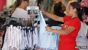 A woman holds a T-shirt inside a shop in Rio de Janeiro, 30 November, 2012