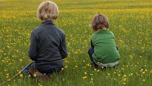 Two children in field - rear view