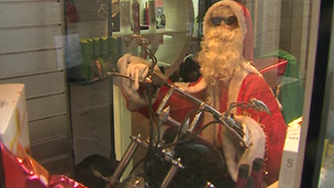 A Santa mannequin rides a motorbike