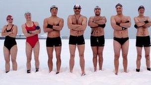 Swimmers stand in the snow on Brighton beach