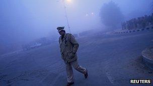 Guard outside the funeral ground in Delhi, India (30 Dec 2012)