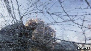 A resident is seen behind the broken windshield of vehicle after a bomb attack in Baghdad's Karrada district