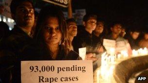 Protesters hold candles and posters during a rally in India on 30 December 2012