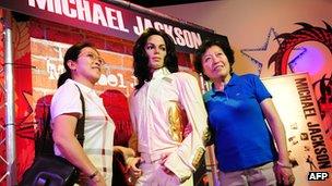 Women pose with Michael Jackson wax figure