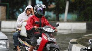 An Acehnese woman rides on the back side of a motorcycle in Banda Aceh, 2 January 2013.