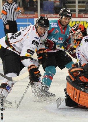 Daymen Rycroft of the Belfast Giants is denied by Mark Thomas and John DeCaro, netminder for the Sheffield Steelers during the Elite League game in Belfast