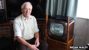 Brian Maley sits next to his black and white TV.