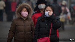 Pedestrians wearing masks in Bejing on 12 January.