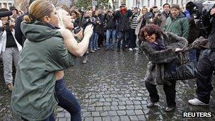 A Femen activist is restrained by a policewoman at the Vatican (13 Jan 2013)