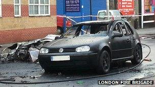 The wreckage of the helicopter next to a damaged car