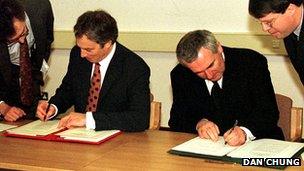 British Prime Minister Tony Blair (l) and Irish Taoiseach Bertie Ahern sign the Good Friday Agreement in Belfast on 10 April 1998