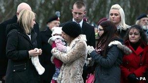 Mourners line the street