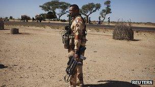 A French soldier holds his weapon in the village of Sarakala, Mali