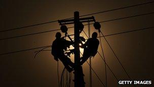 Workers fix power supply wires on a pole in China