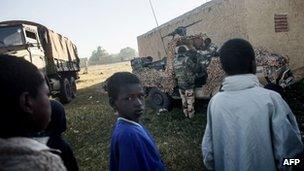 Malian children watch French soldiers